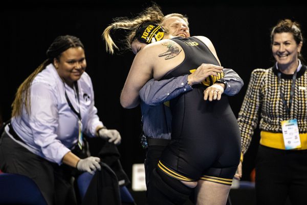 Iowa 191-pound Jaycee Foeller embraces associate head coach Gary Mayabb after pinning North Central College Traeh Haynes during the second day of the National Collegiate Women’s Wrestling Championships at Alliant Energy PowerHouse in Cedar Rapids, Iowa on Saturday, March 9, 2024. (Cody Blissetti/The Daily Iowan)