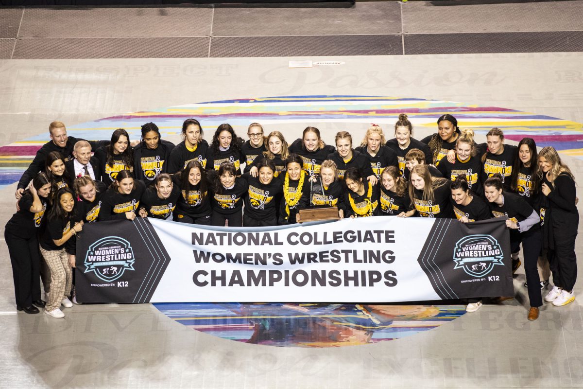 Iowa wrestlers and staff pose for a portrait after winning the National Collegiate Women’s Wrestling Championships at Alliant Energy PowerHouse in Cedar Rapids, Iowa on Saturday, March 9, 2024. 