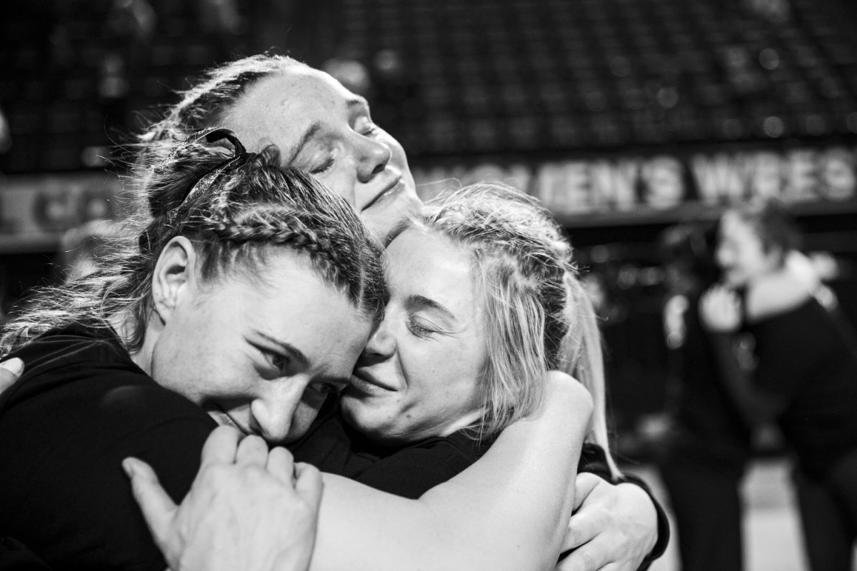 Iowa 116-pound Felicity Taylor, 170-pound Kylie Welker, and 155-pound Marlynne Deede embrace following the second day of the National Collegiate Women’s Wrestling Championships at Alliant Energy PowerHouse in Cedar Rapids, Iowa on Saturday, March 9, 2024.