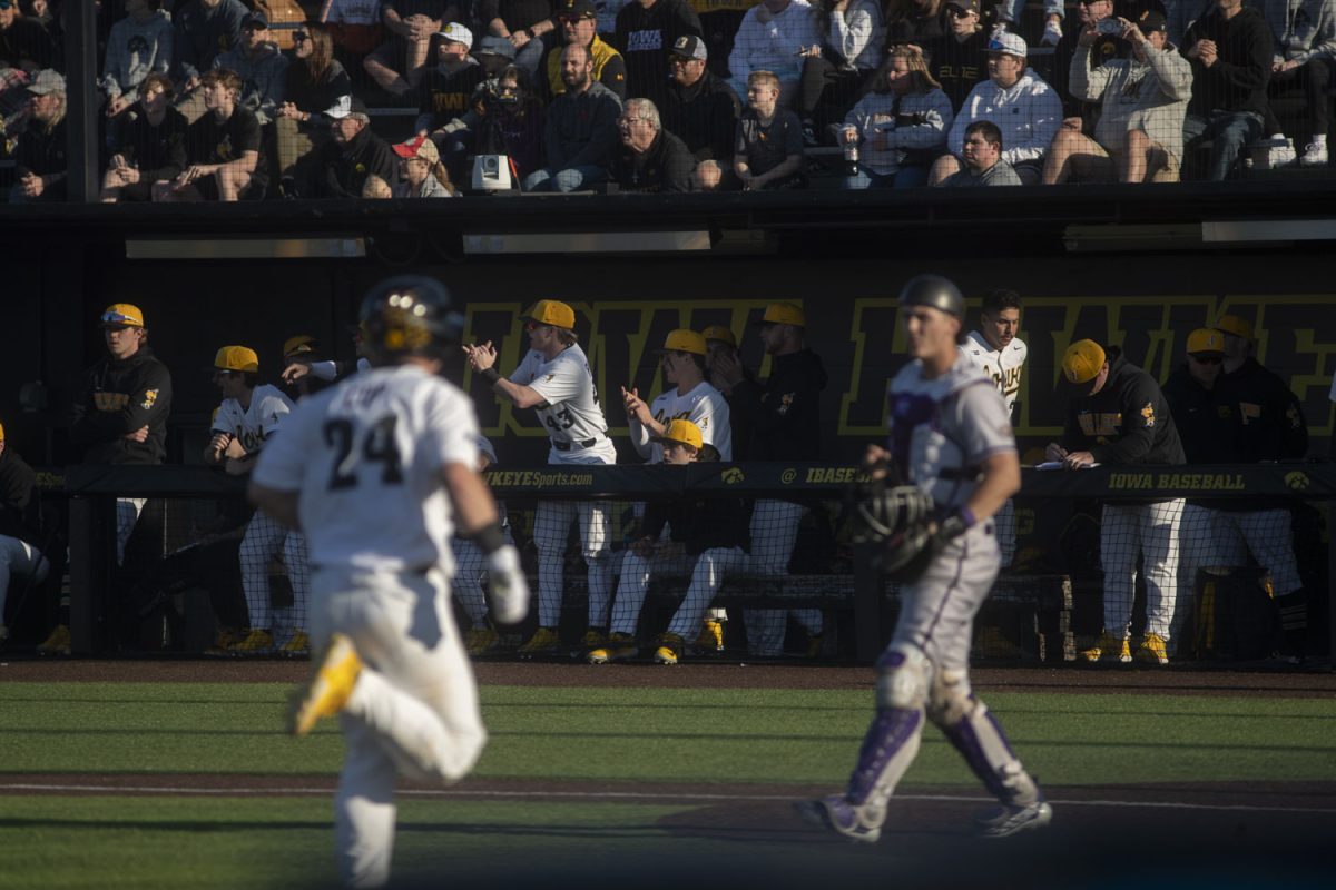 The Iowa dugout cheers as catcher/infielder, Davis Cop runs to home plate during a baseball game between Iowa and Western Illinois at Duane Banks Field on Friday, March 15, 2024. The Hawkeyes would win 11-1 in the eighth inning.