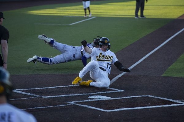 Iowa utility player, Andy Nelson slides into home base to beat the throw during a baseball game between Iowa and Western Illinois at Duane Banks Field on Friday, March 15, 2024. The Hawkeyes would win 11-1 in the eighth inning.