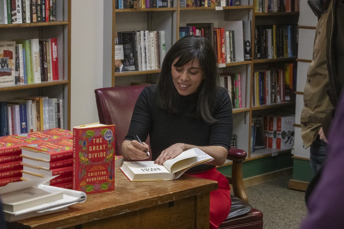 Cristina Henriquez signs a copy of her new novel, “The Great Divide” after a Prairie Lights reading of “The Great Divide” on Friday, March 22, 2024. Henriquez was joined by Writer’s Workshop director Lan Samantha Chang.