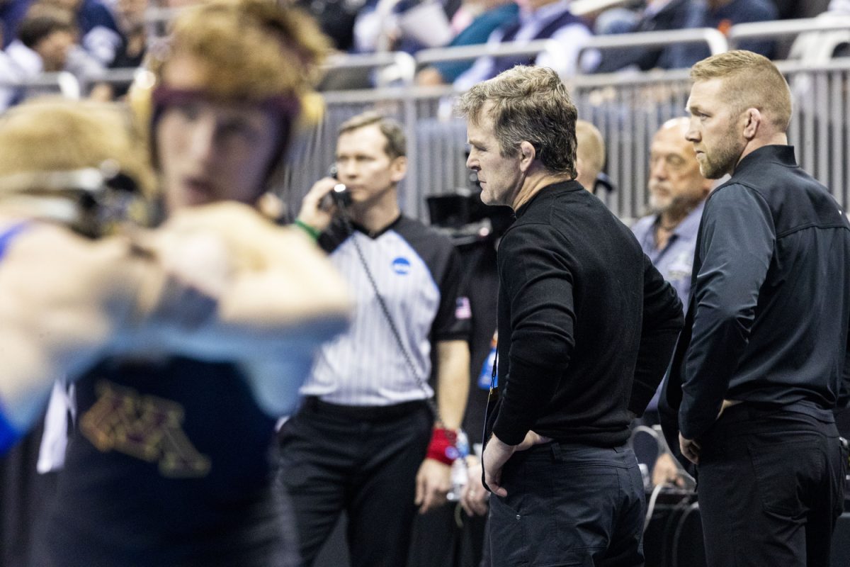 Associate Head Coach Terry Brands observes a match during the third session of the NCAA men’s wrestling championships at T-Mobile Center in Kansas City, Missouri, on Friday, March 22, 2024.
