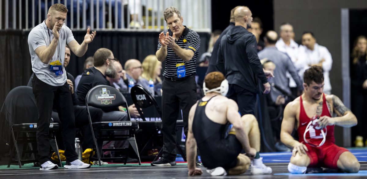 Iowa head coach Tom Brands and assistant coach Ryan Morningstar applaud Iowa 165-pound Mike Caliendo during the third session of the NCAA men’s wrestling championships at T-Mobile Center in Kansas City, Missouri, on Friday, March 22, 2024.