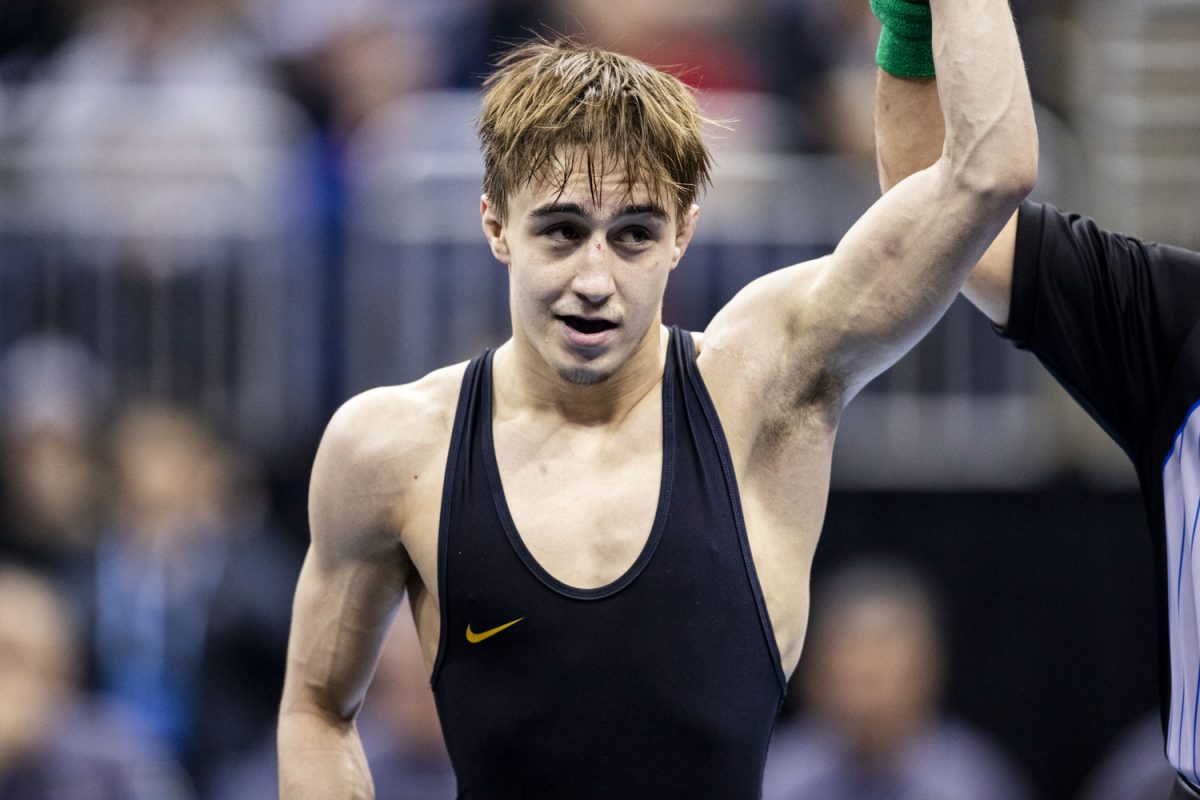 An official holds up Iowa 125-pound Drake Ayala’s arm during the fourth session of the NCAA men’s wrestling championships at T-Mobile Center in Kansas City, Missouri, on Friday, March 22, 2024. Ayala defeated Wisconsin Eric Barnet  by decision, 3-2. 