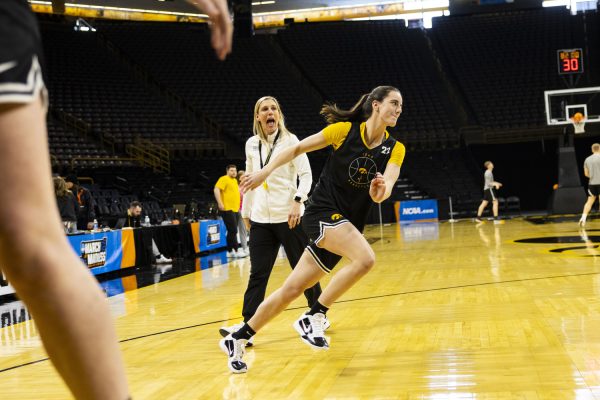 Iowa guard Caitlin Clark runs past associate strength and conditioning coach Lindsay Alexander during a day of press conferences and open practices ahead of an NCAA Tournament First Round game between No. 1 Iowa and No. 16 Holy Cross at Carver-Hawkeye Arena in Iowa City, Iowa, on Friday, March 22, 2024. The Hawkeyes and the Crusaders face off Saturday at 2:00 p.m. CT.
