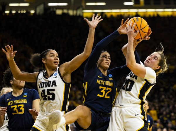 Iowa guard Kate Martin and West Virginia guard Kyah Watson fight for a rebound during an NCAA Tournament Second Round game between No. 1 Iowa and No. 8 West Virginia at Carver-Hawkeye Arena in Iowa City on Sunday, March 24, 2024. The Hawkeyes defeated the Mountaineers, 64-54.