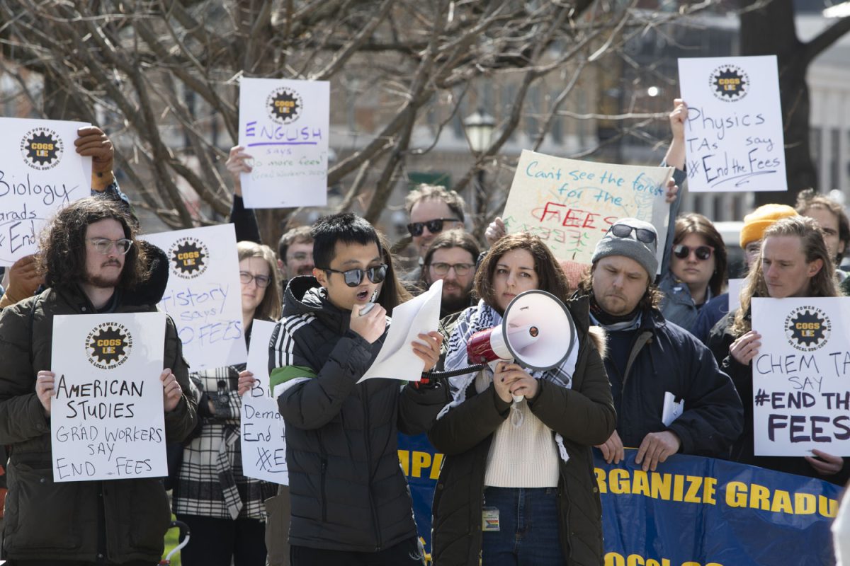 A speaker addresses passing students during a COGS press conference on the University of Iowa Pentacrest on Wednesday, March 27, 2024.