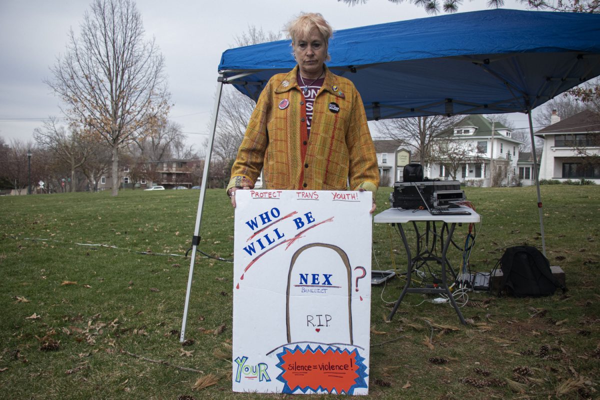 Thresea Meeks-Mosley displays a sign during South East Iowa’s Transgender Day of Visibility at College Green Park in Iowa City on Sunday, March 31, 2024.
