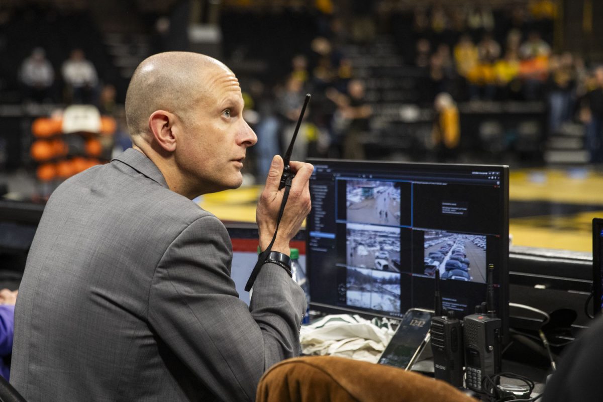 Iowa Assistant Athletics Director Josh Berka talks on a walkie talkie during a women’s basketball game between Iowa and Nebraska on Saturday, Jan. 27, 2024.