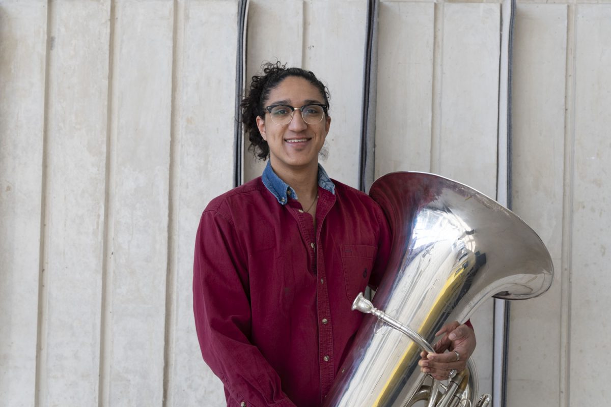John Reyna, a graduate teaching assistant and tubist, poses for a photo in the Voxman Music Building on Friday, March 29, 2024. Reyna has previously had musicians dystonia. Musician’s dystonia is a movement disorder that results in a loss of voluntary motor control in extensively trained movements. 