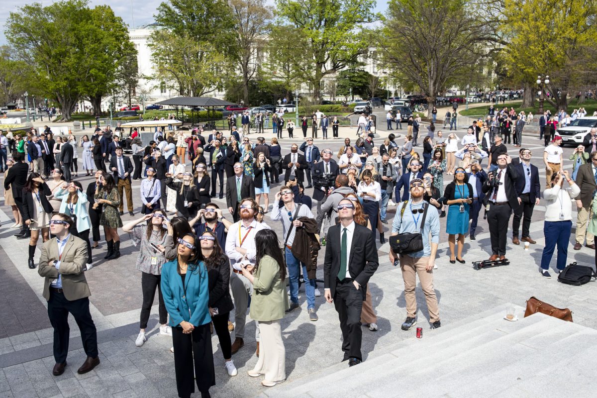 People gather outside the U.S. Capitol in Washington D.C. to observe a solar eclipse on Monday, April 8, 2024. D.C. experienced an 89% totality with the maximum eclipse happening at 3:20 p.m.