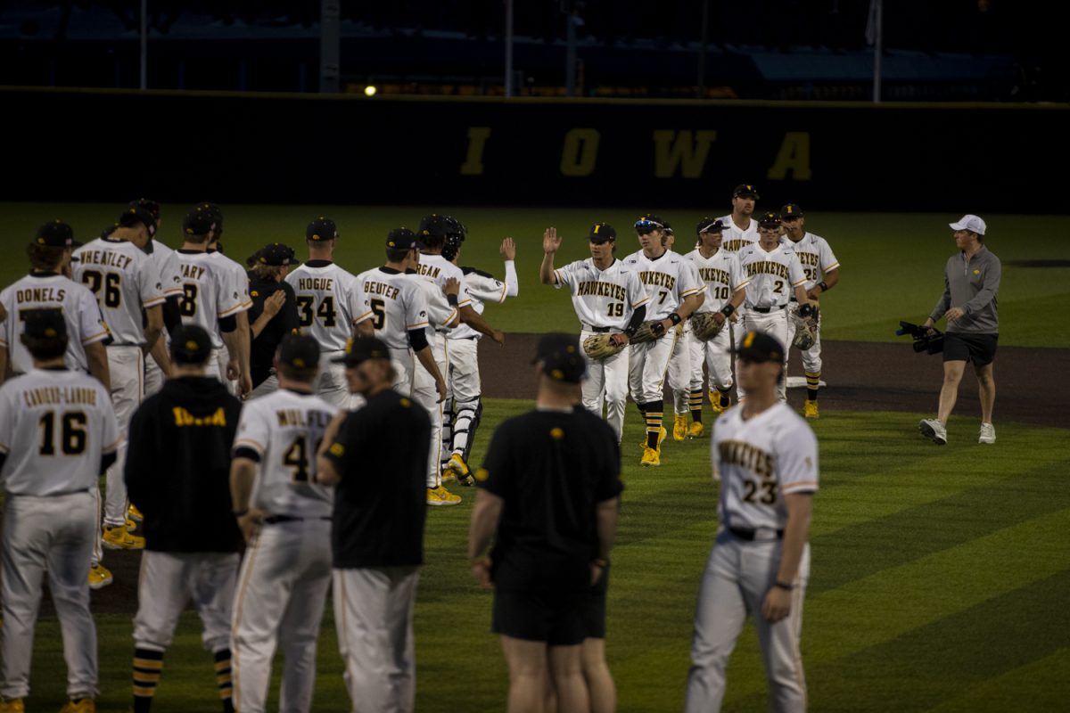 Iowa players high five after securing the win after a baseball game between St. Thomas and Iowa at Duane Banks Field in Iowa City, Iowa. The Hawkeyes defeated the Tommies 17-11.