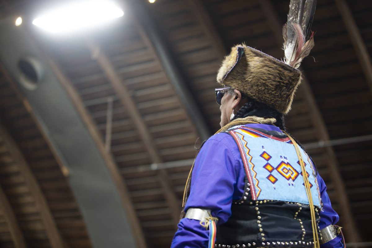 A dancer walks into the arena during the University of Iowa Powwow at the Johnson Country Fairgrounds on Saturday, April 20, 2024.
