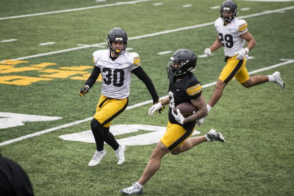 Iowa defensive back Quinn Schulte looks to tackle Iowa Wide receiver Kaleb Brown during a scrimmage at a spring practice at Kinnick Stadium on Saturday, April 20, 2024. The Hawkeyes held a free open practice for fans.