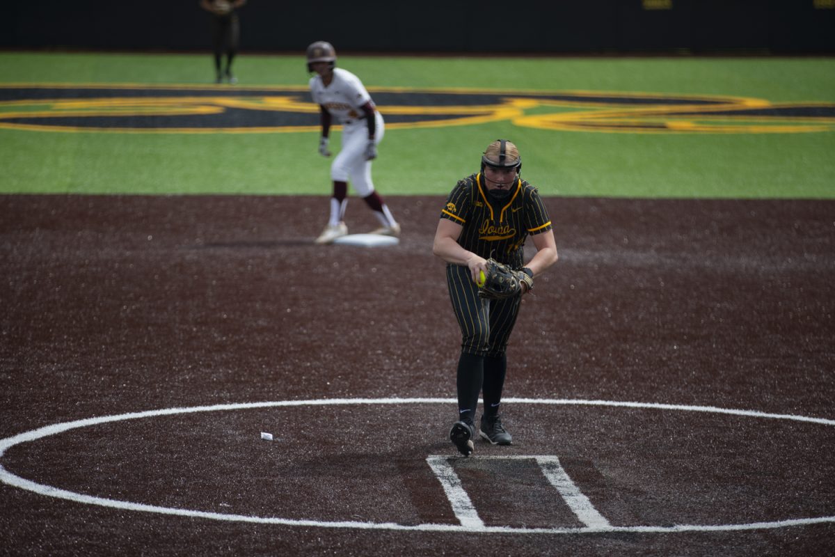 Iowa pitcher Jalen Adams winds up with a runner on second during the first of a three-game softball series between Iowa and Minnesota at Bob Pearl Field on Saturday, April 27, 2024. The Gophers defeated the Hawkeyes 7-5.