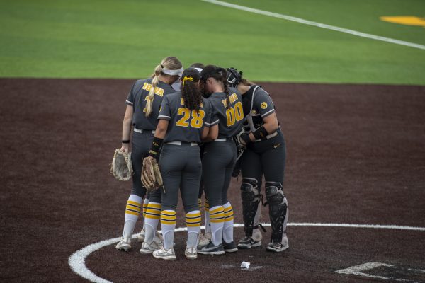 Iowa players meet on the mound during a softball game between Minnesota and Iowa at Bob Pearl Field in Iowa City, Iowa. The Golden Gophers defeated the Hawkeyes 6-2 in extra innings.