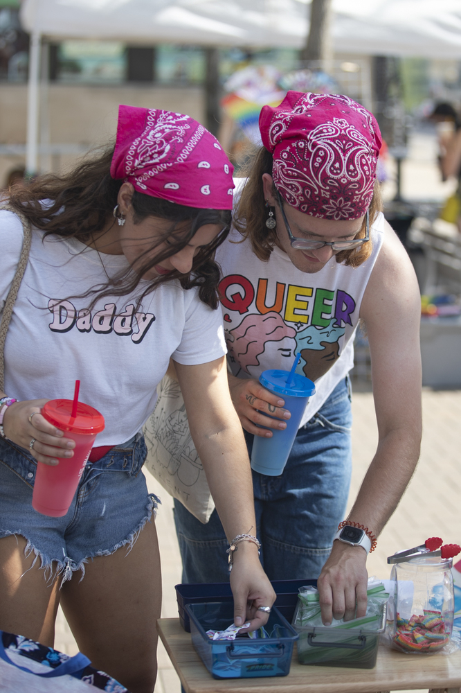 Attendees look at stickers during the 53rd annual pride parade and festival in downtown Iowa City on Saturday, June 15, 2024. The event included a parade, performances, and local vendor stations around downtown. (Shaely Odean/ The Daily Iowan)