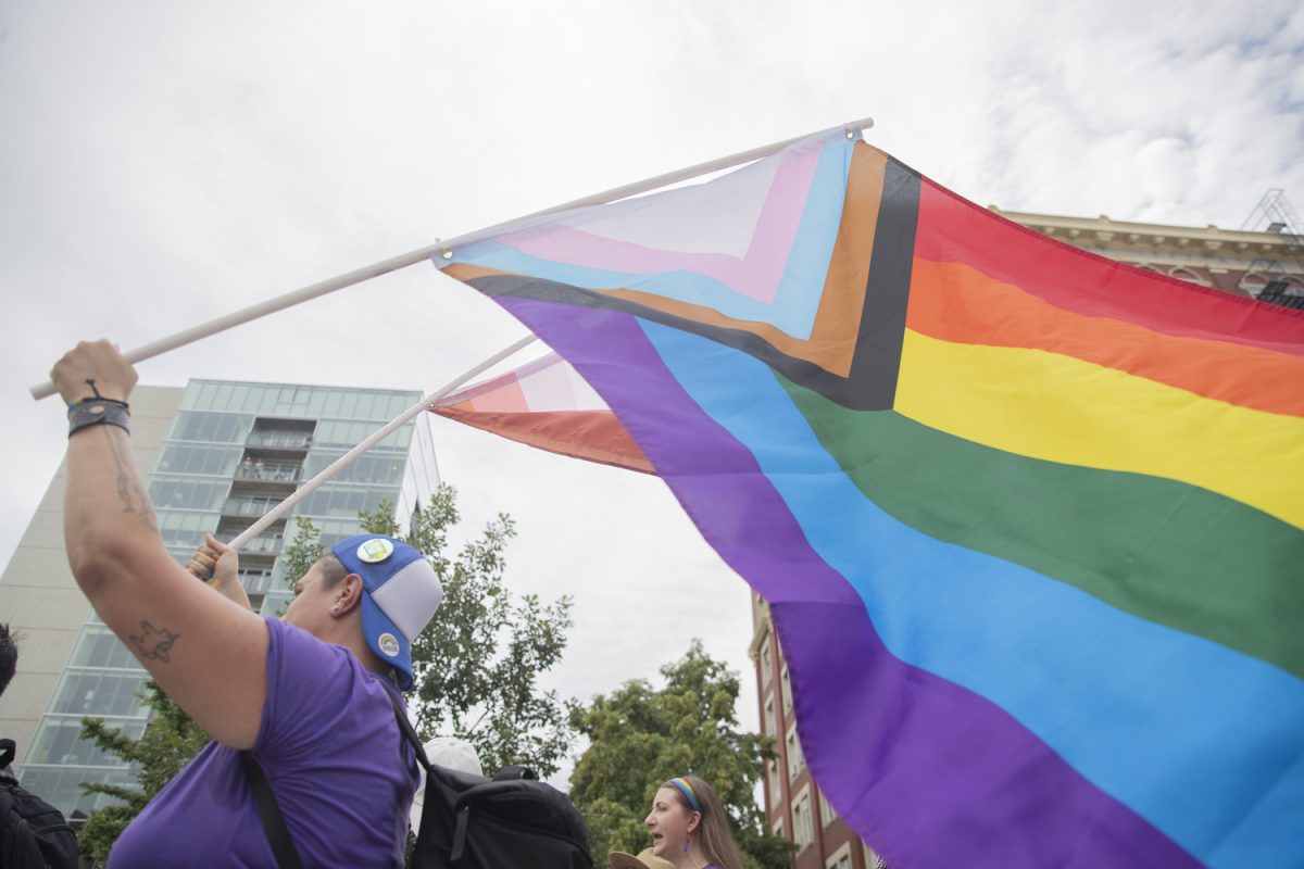 A parade member holds up a pride flag during the 53rd annual pride parade in downtown Iowa City on Saturday, June 15, 2024. The event included a parade, performances, and local vendor stations around downtown.