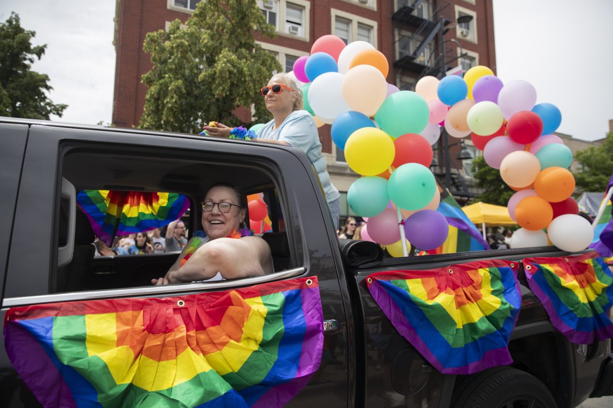 Parade members ride on a truck during the 53rd annual pride parade in downtown Iowa City on Saturday, June 15, 2024. The event included a parade, performances, and local vendor stations around downtown.