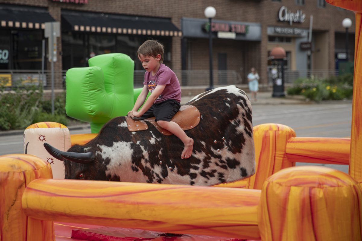 A child ride the mechanical bull during the 7th annual Downtown Iowa City Block Party on Saturday, June 22, 2024. 
