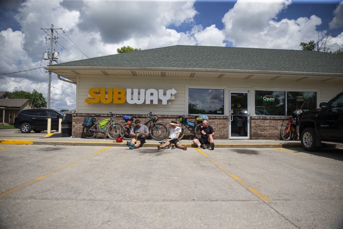 Sayre Satterwhite, Ben Eastman and Steve McGuire sit in front of a Subway after eating lunch in Red Oak, Iowa on Saturday, June 1, 2024. On day one of the Design, Build and Ride Iowa bicycle tour, participants covered 75 miles with over 2,700 vertical feet of climbing. 