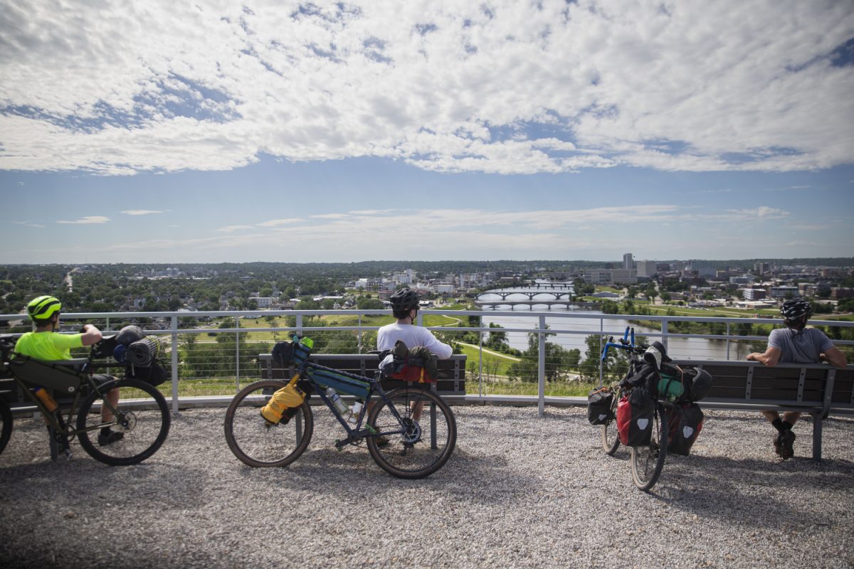 David Butler, Elijah Mickey and Jason McCartney look at the skyline of Cedar Rapids, Iowa from the top of Mt. Trashmore on Wednesday, June 5, 2024. On day five of the Design, Build and Ride Iowa bicycle tour, participants covered 110 miles with over 2,000 vertical feet of climbing. 