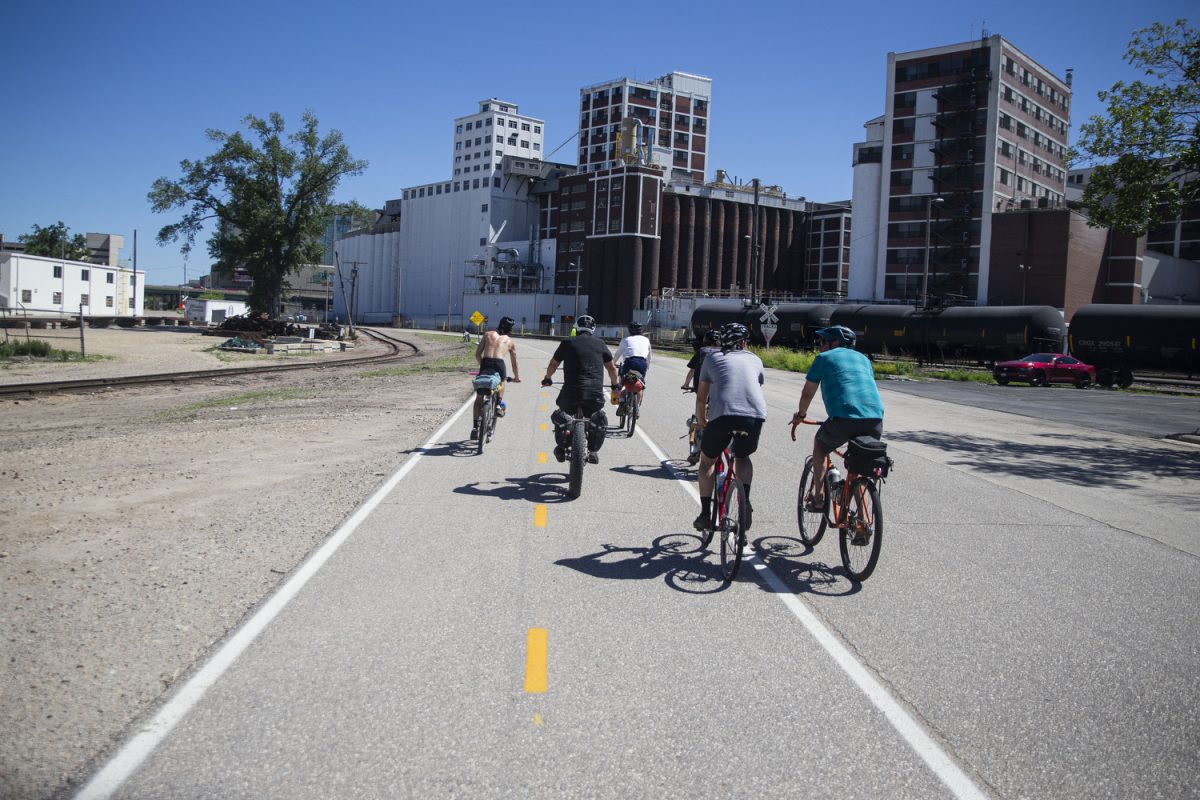 Participants of the Design, Build and Ride Iowa bicycle tour ride past the Quaker Oats factory on the Cedar Valley Nature Trail in Cedar Rapids, Iowa on Wednesday, June 5, 2024. On day five of the Design, Build and Ride Iowa bicycle tour, participants covered 110 miles with over 2,000 vertical feet of climbing. 