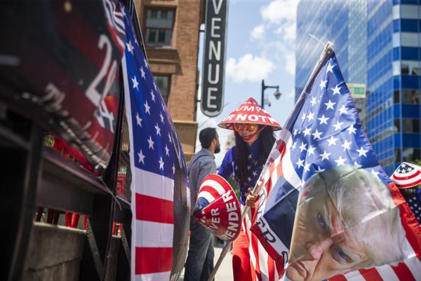 Kimberly Nguyen picks up a flag to wave during the third day of the 2024 Republican National Convention in Milwaukee, WI on Wednesday, July 17, 2024. Nguyen traveled from California to show support for former President Donald Trump.