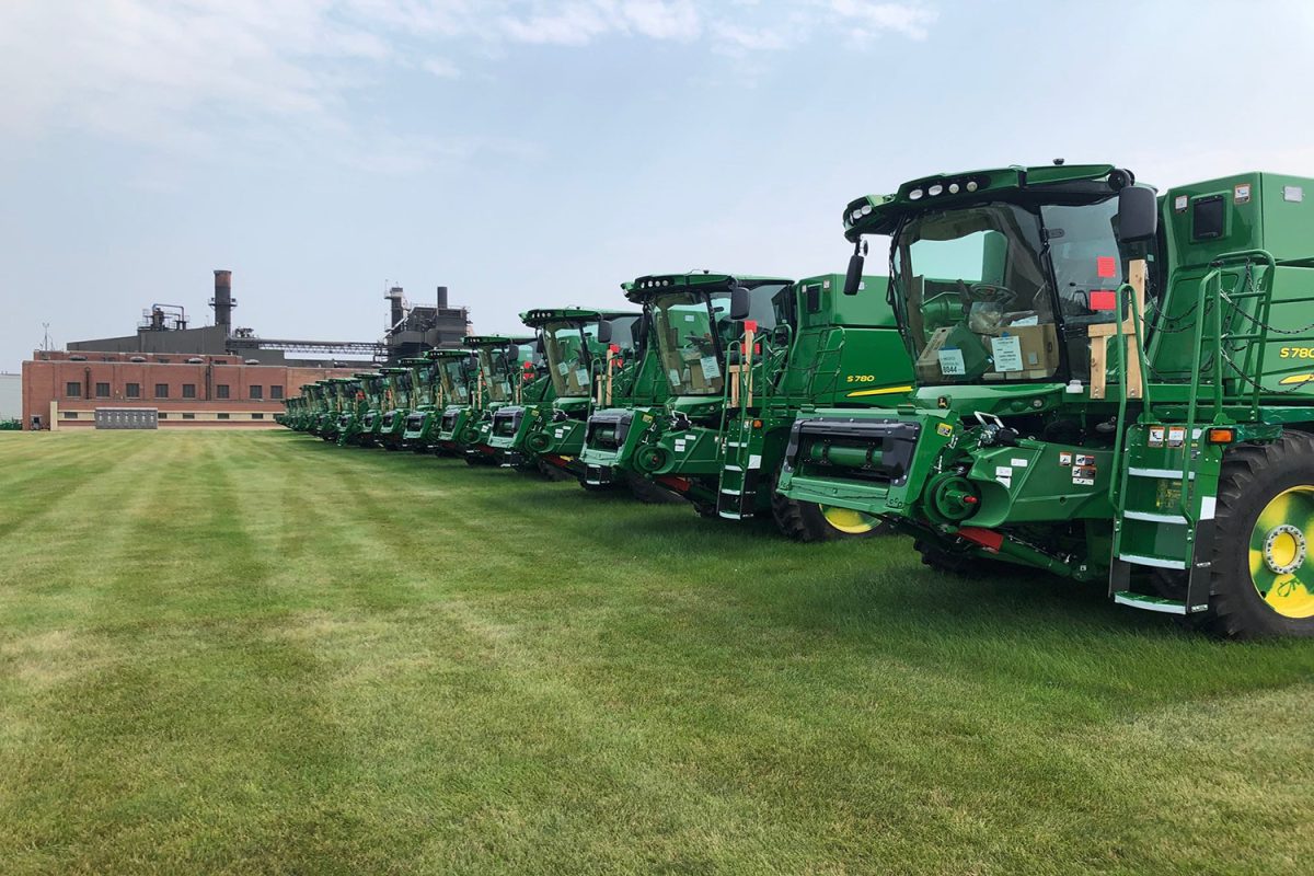 A row of John Deere farming equipment lined up outside the company's factory.

John Deere Img 1300