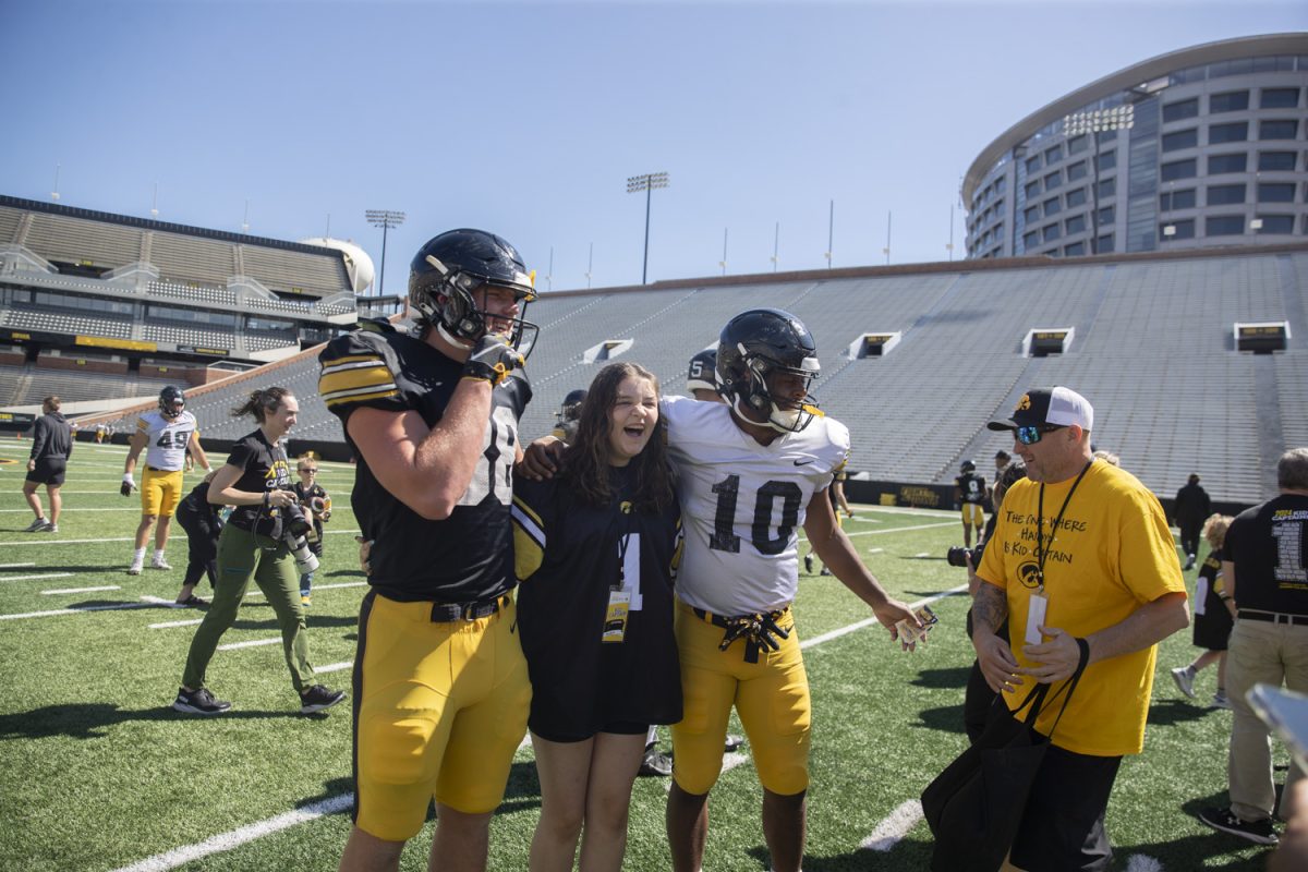 Kid Captain Haidyn Ulrich takes a photo with Nick Jackson and Graham Eben during Kid’s Day at Kinnick Stadium on Saturday, Aug. 10, 2024. Iowa football players signed autographs for young fans and held an open practice on the Kinnick field.