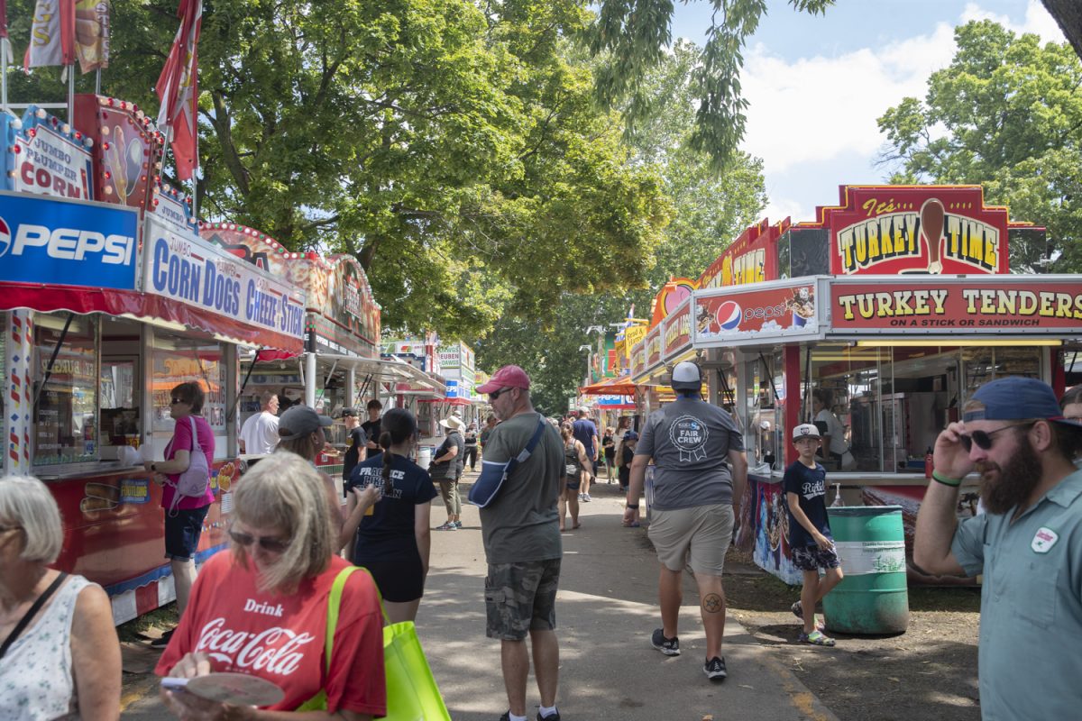 Fairgoers buy food from stands during day eight of the Iowa State Fair at the Iowa state fairgrounds in Des Moines on Thursday, August. 15, 2024.