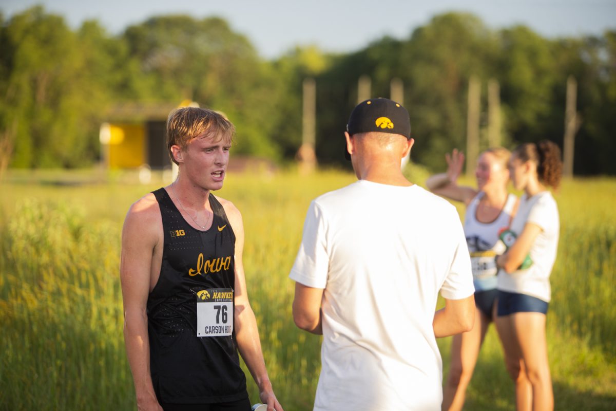 Carson Houg rests after the men’s 6K race during the Hawkeye Invite at Ashton Cross Country Course in Iowa City on Friday, Aug. 30, 2024. Houg finished with a time of 18:49.8 and came in 20th place overall.