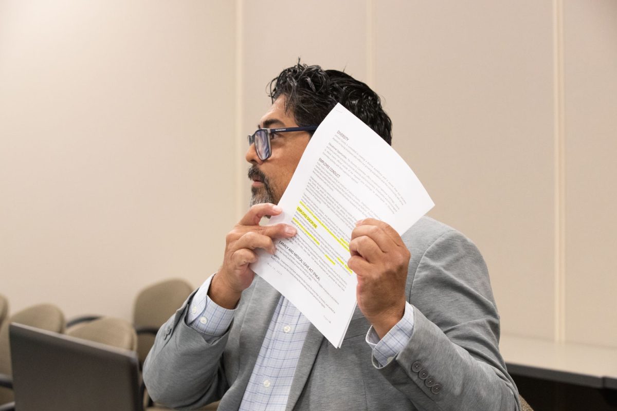 Johnson County Board of Supervisors Executive Director Guillermo Morales shows the Board the rules concerning employee discipline during a Johnson County work session on Wednesday, Sept. 4, 2024. Morales was terminated by a 3 to 2 vote.