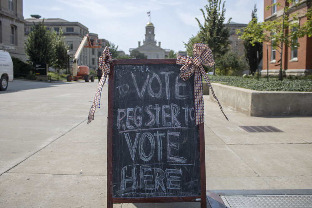 A sign sits on the T. Anne Cleary Walkway during a Hawk the Vote campaign on Sept. 5. The organization set up tents across Iowa City to encourage UI students to register to vote.