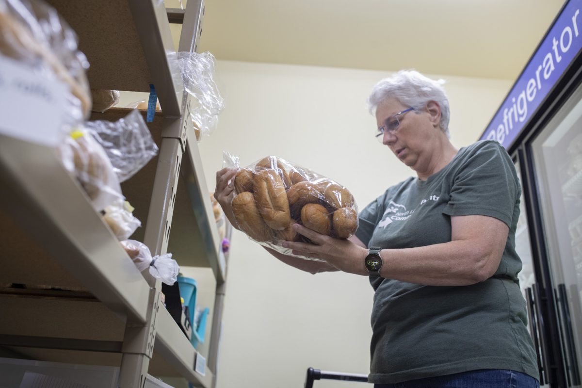 Pantry volunteer Becky Hays checks bread for mold before the opening of the North Liberty Food Pantry on Sept. 5, 2024. Food pantries around Iowa saw increased usage over the summer. 