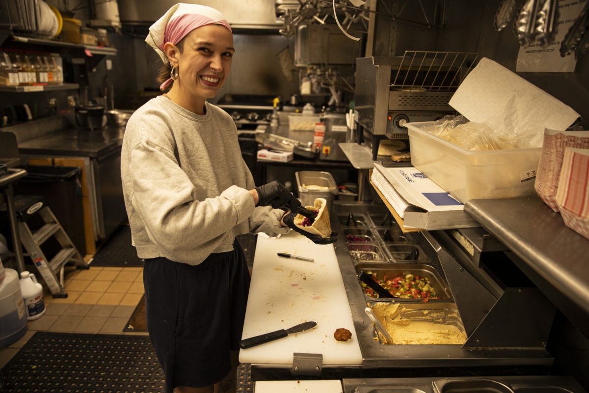 Oasis employee Marin Irvine makes a pita sandwich after a ribbon-cutting event in celebration of Oasis Falafel’s 20-year anniversary in business, sponsored by Greater Iowa City Inc., on Thursday, Sept. 5, 2024. Owners Naftaly Stramer and Ofer Sivan created Oasis Falafel in the summer of 2004.