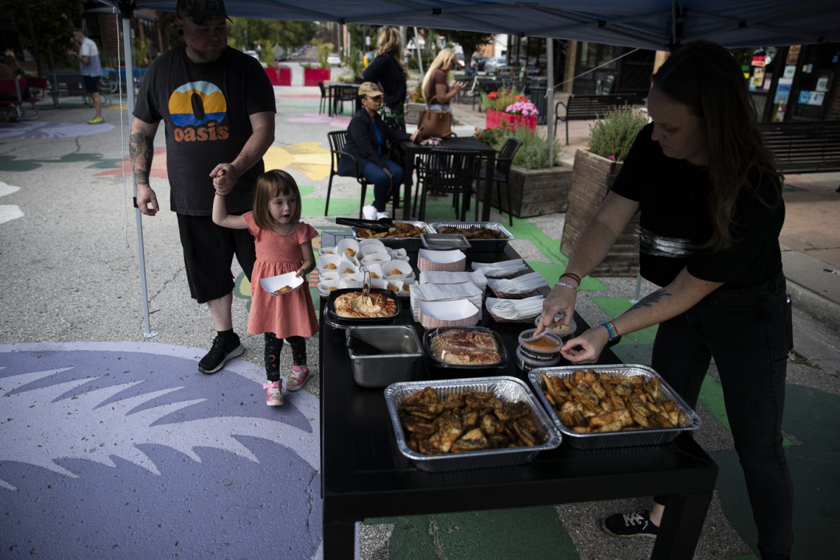 A worker helps prepare a table of food during a ribbon-cutting event in celebration of Oasis Falafel’s 20-year anniversary in business, sponsored by Greater Iowa City Inc., on Thursday, Sept. 5, 2024. Owners Naftaly Stramer and Ofer Sivan created Oasis Falafel in the summer of 2004.