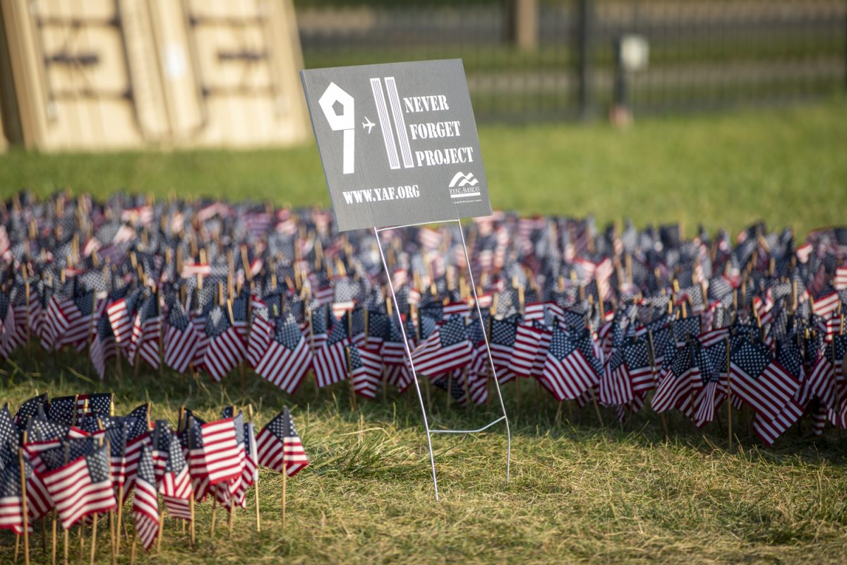 A 9/11 remembrance sign is posted during a Young Americans for Freedom event at Hubbard Park in Iowa City on Wednesday, Sept. 11, 2024. The group set up flags and held an event to honors those lost on Sept. 11, 2001.