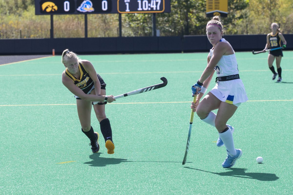 Iowa forward Rachel Herbine sends a pass through defenders during a field hockey match between Iowa and Delaware at Grant Field on Sept. 15. The Hawkeyes defeated the Blue Hens, 1-0. 