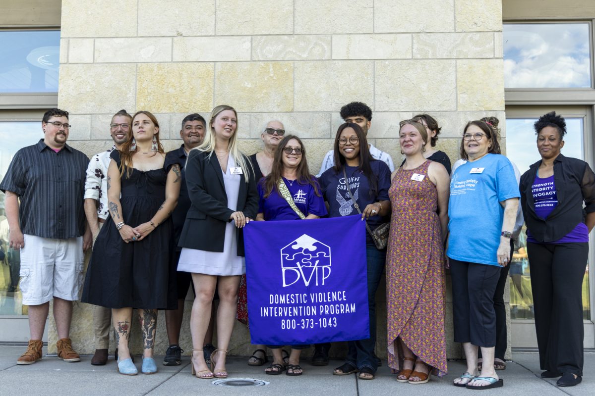 Staff members hold the DVIP flag at the organizations 45th Anniversary Celebration in Coralville on Sept. 19, 2024. This included a ribbon-cutting ceremony for the new facilities DVIP is opening thanks to funding from the community. 