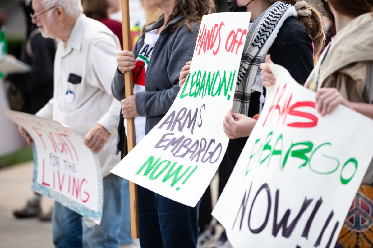 Activists raise signs during a pro-Palestine protest in solidarity with Lebanon on the Pentacrest in Iowa City on Tuesday, Sept. 24, 2024. Protesters held signs, chanted, and listened to speakers on the side of N. Clinton St.