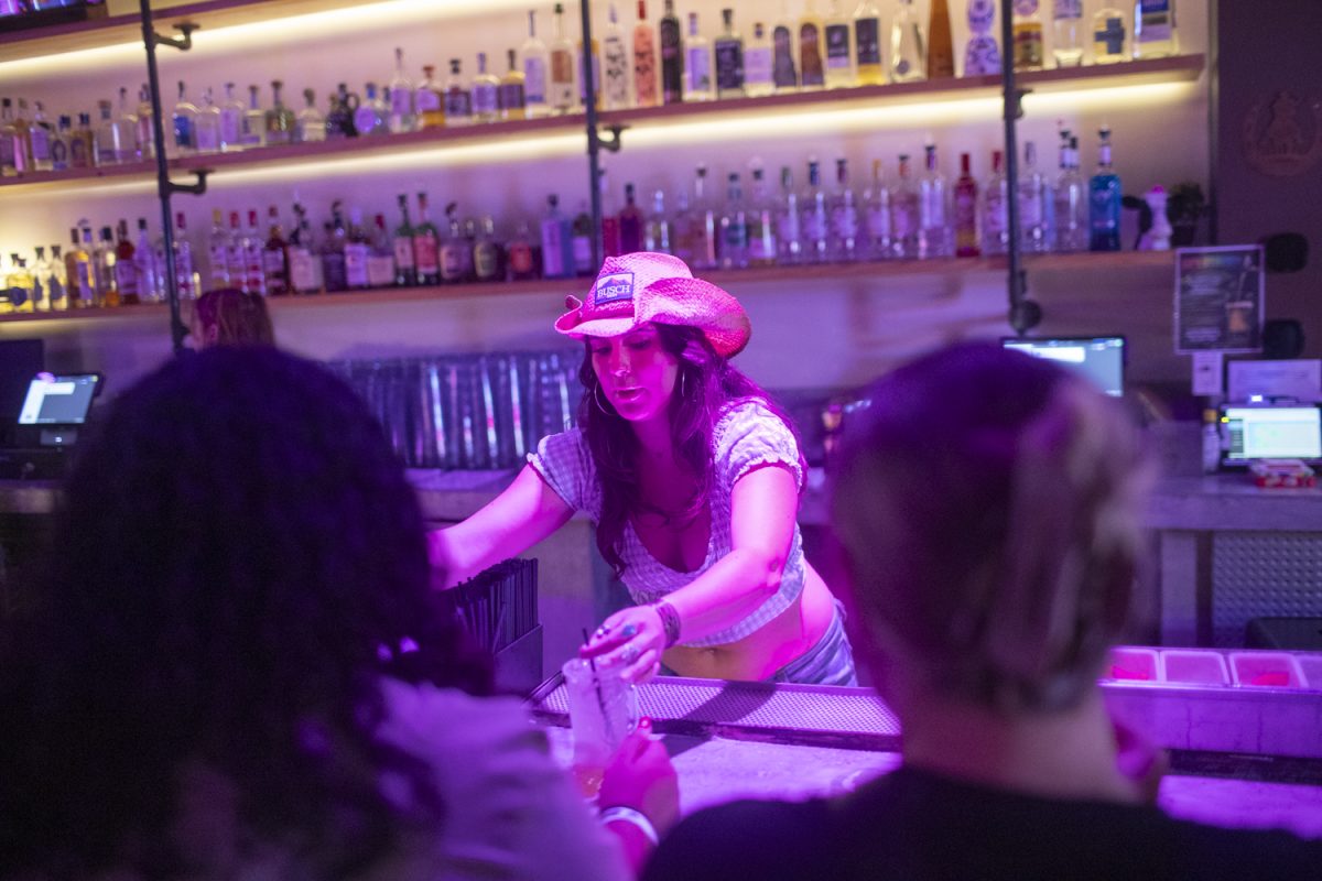 A bartender pours a drink for patrons at new country nightclub Tequila Cowgirl on Friday, Aug. 30, 2024. The bar is in the former location of Bardot and Casa Azul, and owned by Spectrum Hospitality Group, which also runs the club Studio 13.