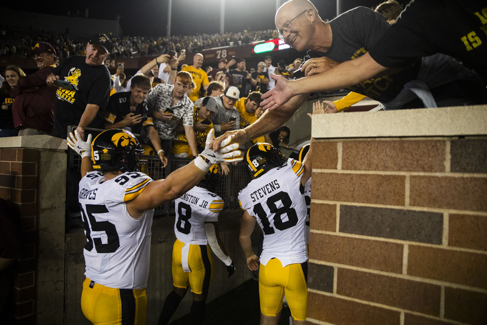 fans high-five players after a football game between Iowa and Minnesota at Huntington Bank Stadium in Minneapolis, MN on Saturday, Sept. 21, 2024. The Hawkeyes defeated the Golden Gophers 31-14, taking back the Floyd of Rosedale Trophy.