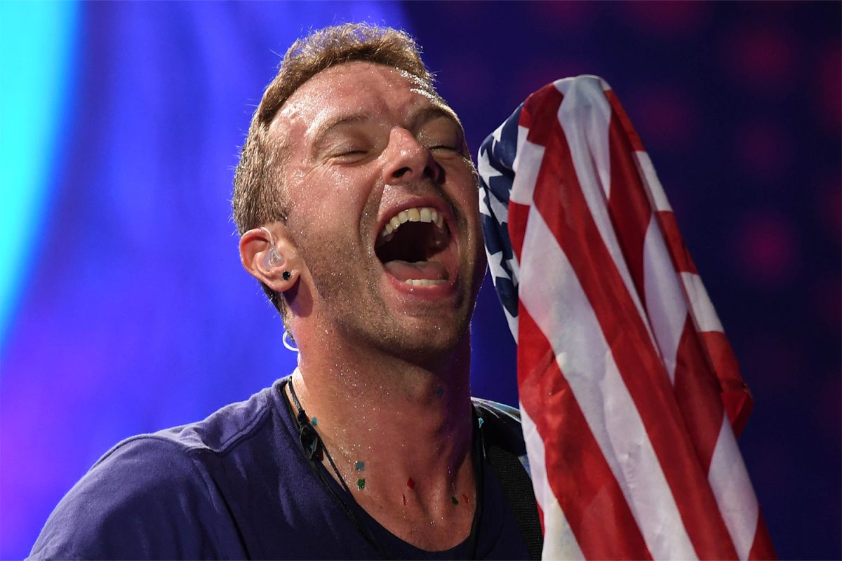 Aug 28, 2017; Miami Gardens, FL, USA; Chris Martin of Coldplay performs with an American flag at the Hard Rock Stadium.