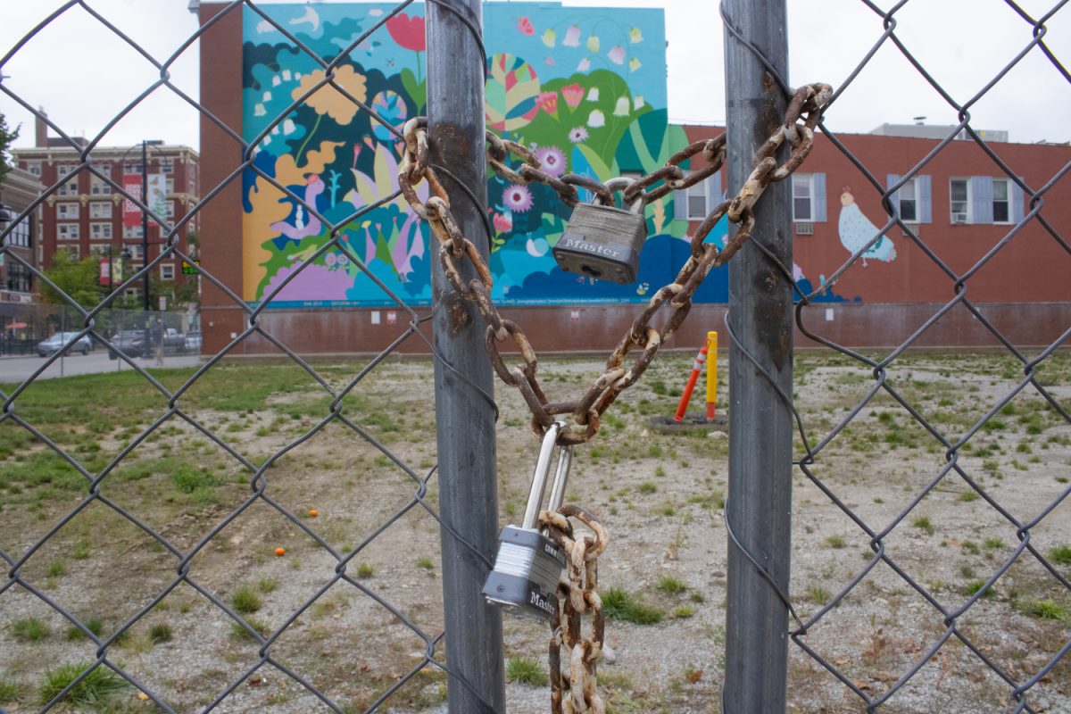 A lock dangles from a fence on the open lot across from the Senior Center on Linn Street in Iowa City on Wednesday, Sept. 27, 2023. The city of Iowa City released a request for proposals for the lot on Thursday. 