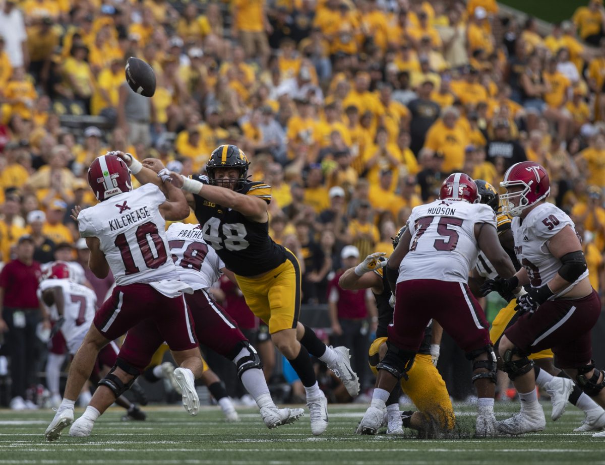 Iowa defensive lineman Max Llewellyn and Troy quarterback Tucker Kilcrease reach for a loose ball during a football game between Iowa and Troy at Kinnick Stadium on Saturday, Sept. 14, 2024. The Hawkeyes defeated the Trojans, 38-21. Llewellyn tackled once throughout the game.