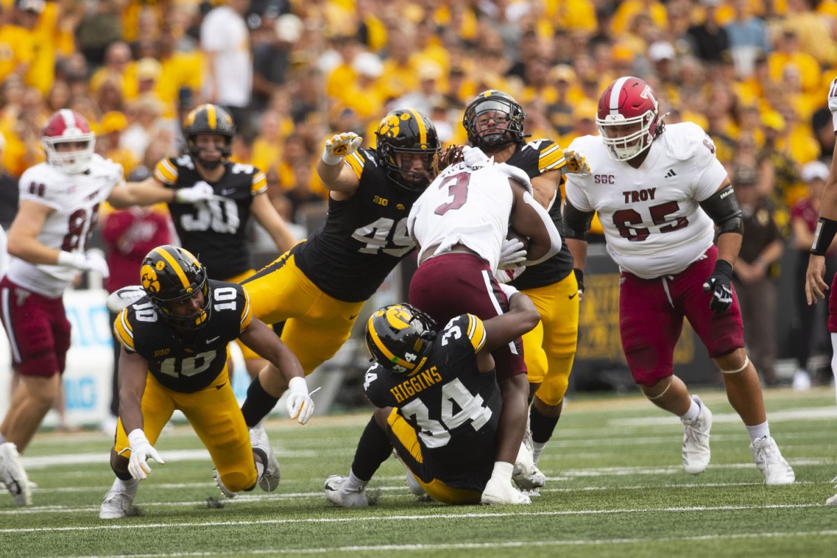 Iowa defensive lineman Ethan Hurkett and Iowa linebacker Jay Higgins tackle a Trojan player during a football game between Iowa and Troy at Kinnick Stadium on Saturday, Sept. 14, 2024. The Hawkeyes defeated the Trojans, 38-21. Hurkett had four solo tackles. 