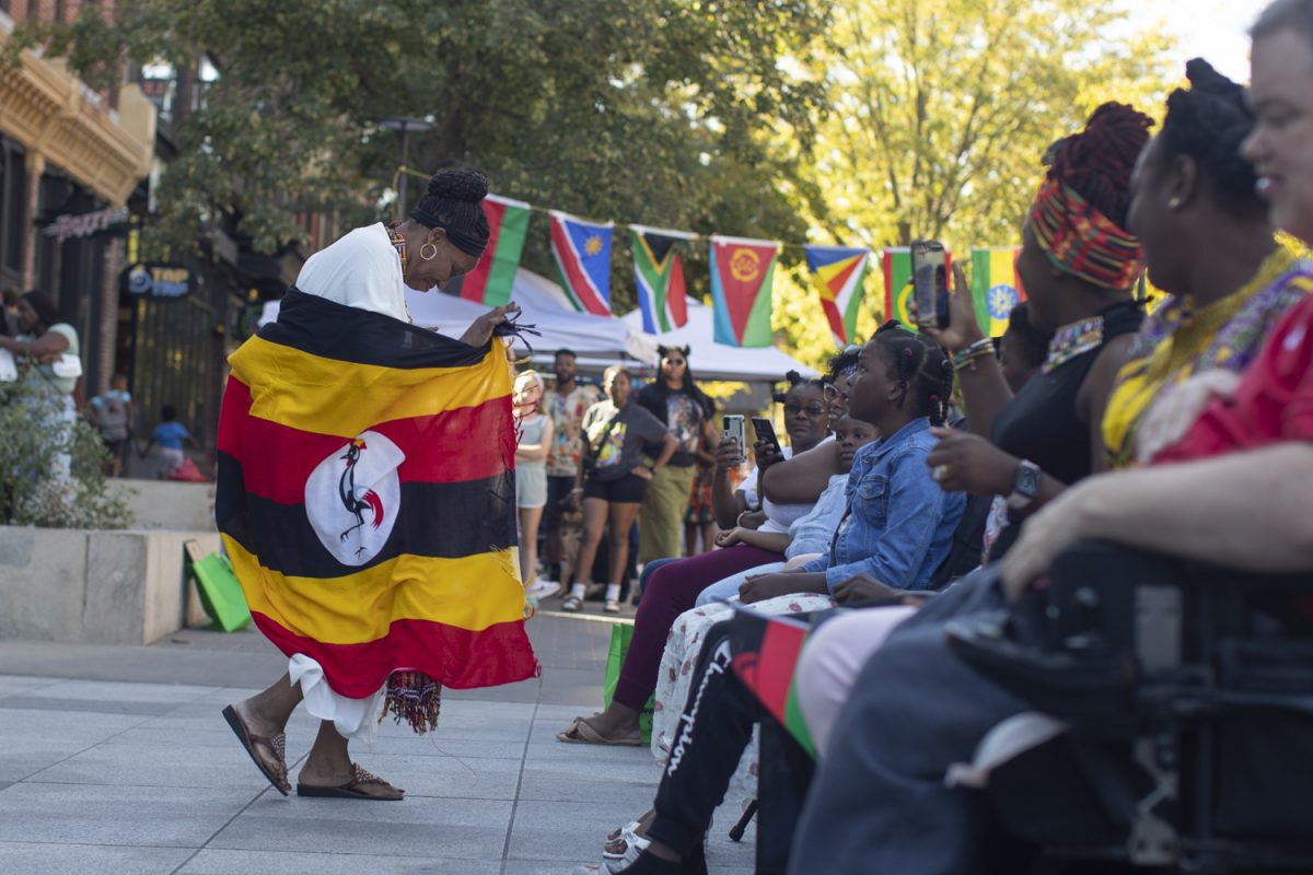 A dancer from Uganda approaches the audience during the first-ever African Festival of Arts and Culture in the Pedestrian Mall in Iowa City on Sept. 28, 2024. Over a dozen vendors sold food, jewelry, and clothing from a variety of African countries.