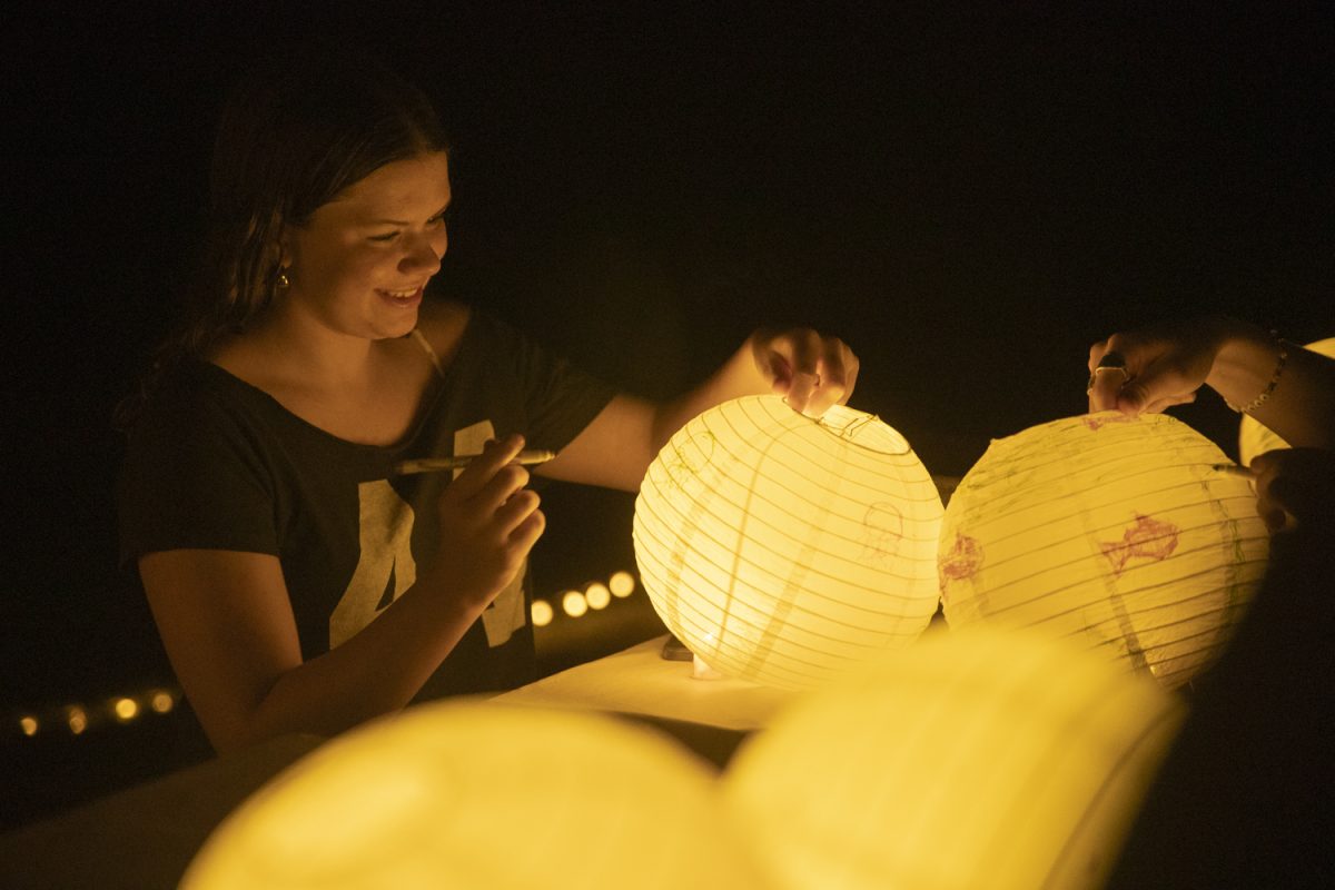 A festival goer decorates a lantern during the Golden Beaker Lantern Festival at Hickory Hill Park on Sept. 28, 2024. All funds from this event will help low-income schools in the Iowa City area. 